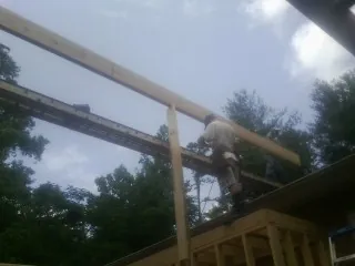 Carpenter setting a ridge beam over a new addition frame — Ice Dam Removal by Roofing Brothers in Brownstown