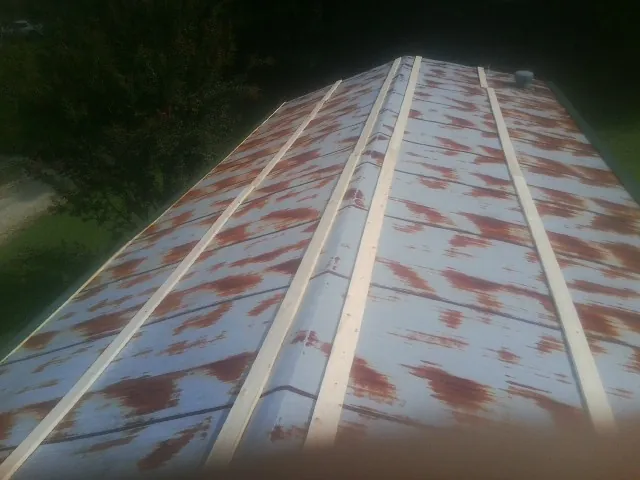 Rusted metal roof panels with new wood purlins before replacement — Storm Damage Roof Repair in Brownstown by Roofing Brothers