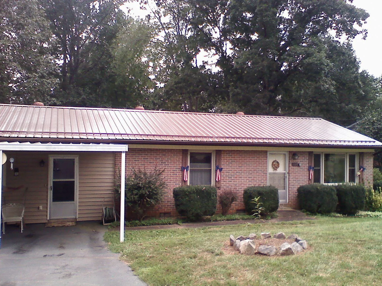 Bronze metal roof and carport on a brick ranch home — Roof Repair work by our crew in Brownstown