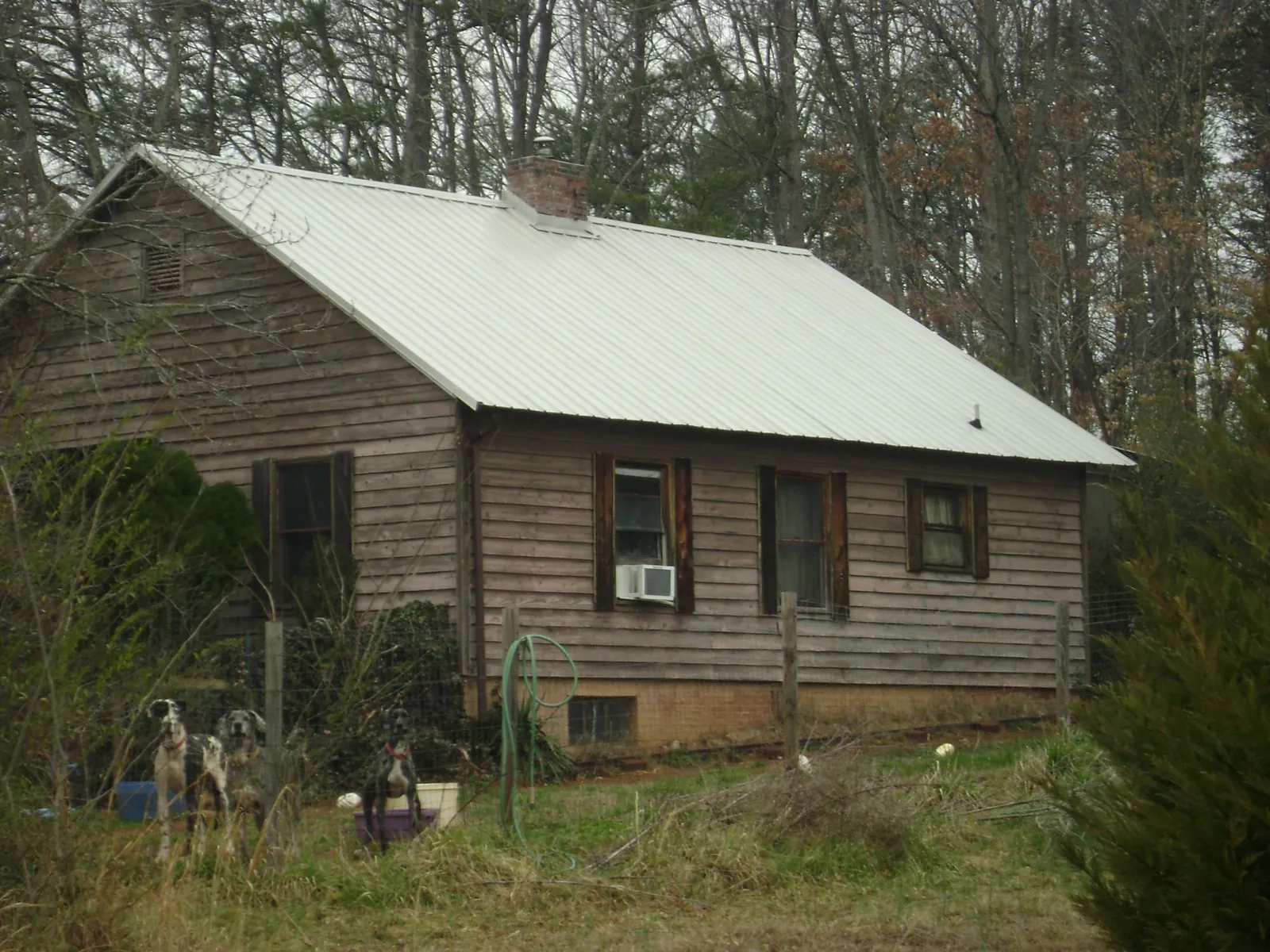 White metal roof on an old wood sided farmhouse, from a Metal Roof Installation job in Brownstown
